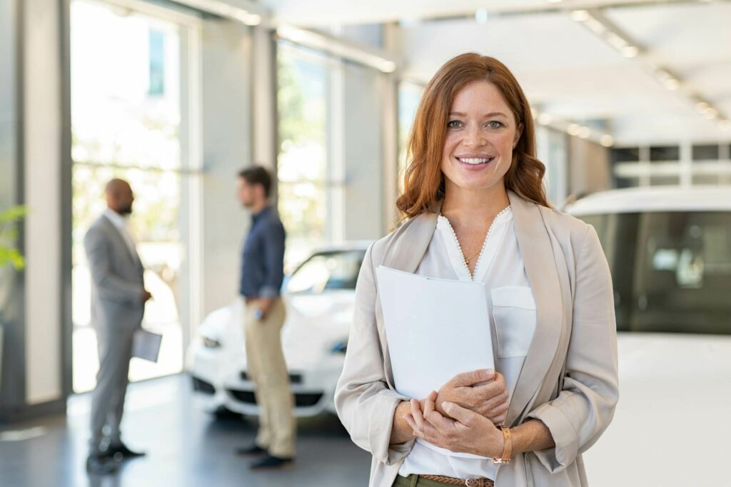 satisfied saleswoman in car dealership